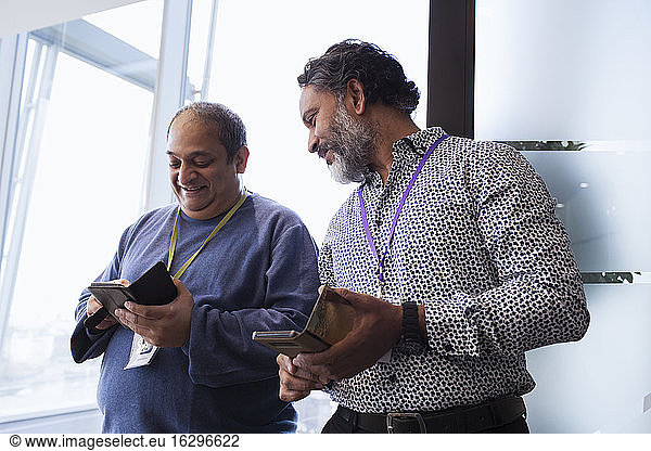 Businessmen using smart phones in office