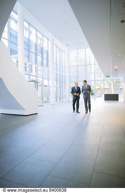 Businessmen walking together in office building