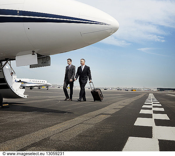Businessmen walking towards corporate jet