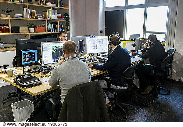 Businessmen working on desktop PC in office