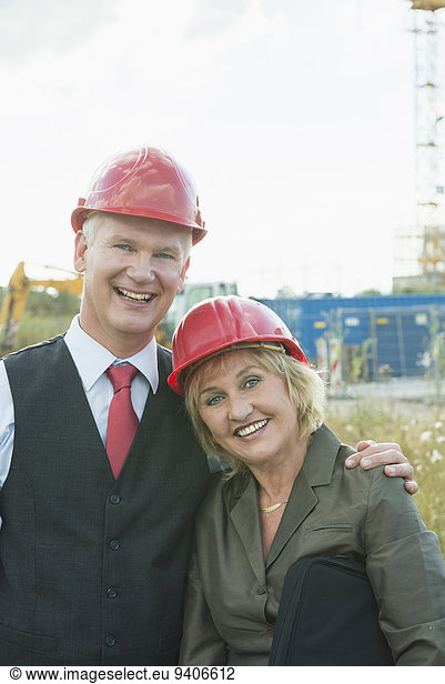 Businesspeople on site wearing safety helmets