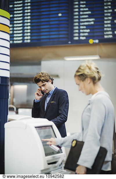 Businesspeople using check in machines at airport