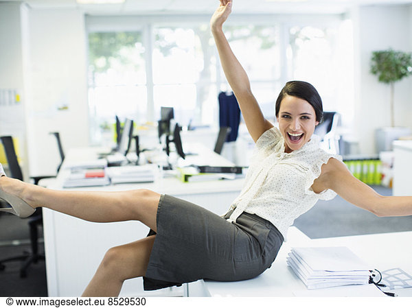 Businesswoman cheering in office