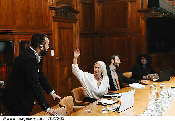 Businesswoman discussing with businessman during meeting in board room