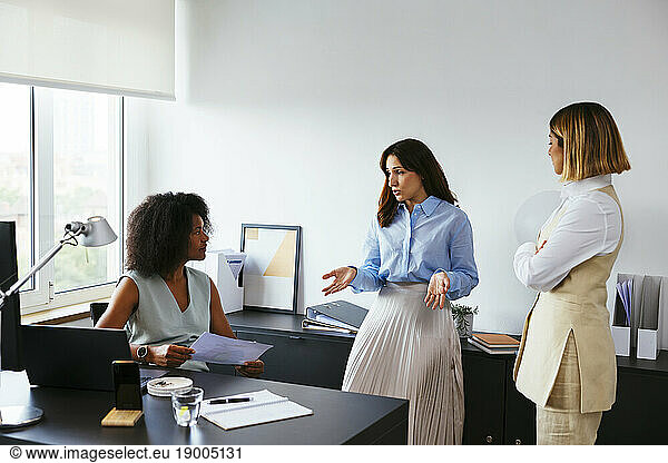Businesswoman discussing with colleagues in meeting at office