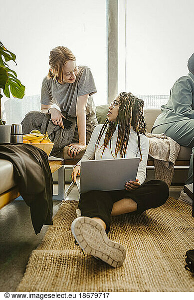 Businesswoman discussing with female colleague in creative office
