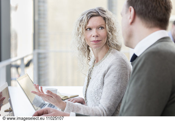 Businesswoman discussing with male colleague in office