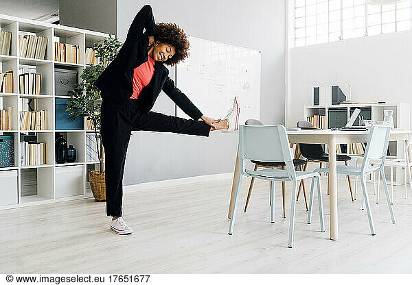 Businesswoman doing stretching exercise at desk in office