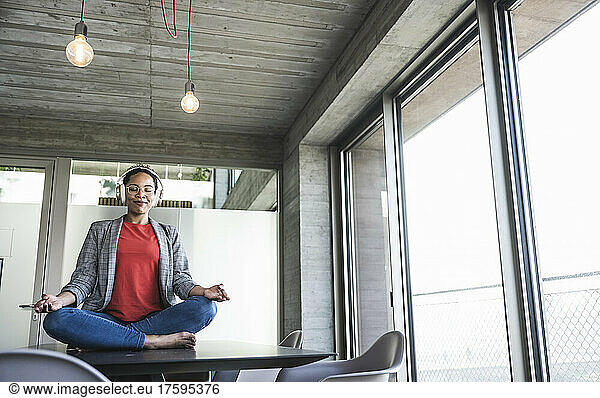 Businesswoman doing yoga at work place