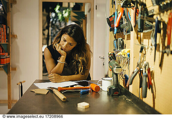 Businesswoman examining document at bicycle shop