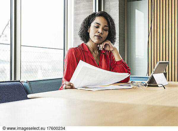 Businesswoman examining documents at desk in office