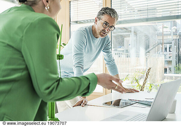 Businesswoman having discussion with colleague in office