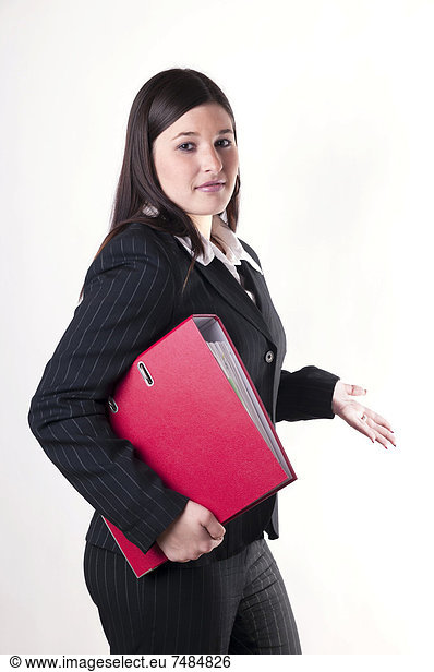 Businesswoman holding a red folder in her arm with a questioning attitude