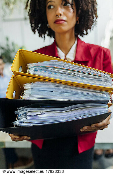 Businesswoman holding file folders in office