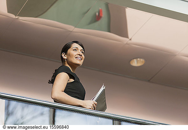 Businesswoman holding folders on stairs of office building