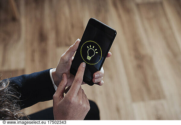 Businesswoman holding smart phone with flashlight icon
