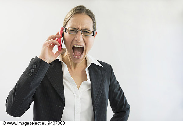 Businesswoman in black suit shouting on smart phone