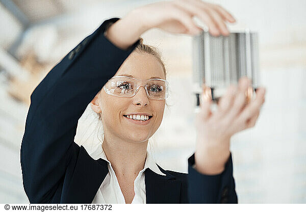 Businesswoman looking at building model in office