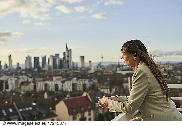 Businesswoman looking at view while standing on rooftop