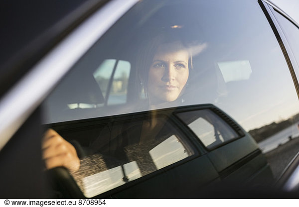 Businesswoman looking through window while driving car