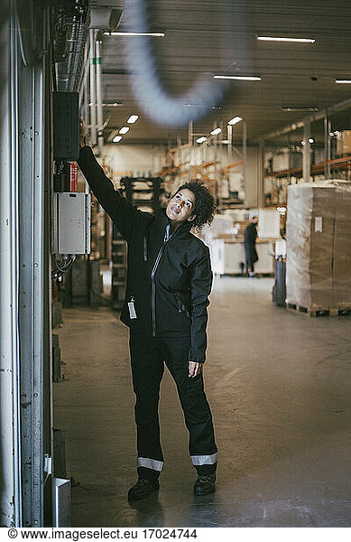 Businesswoman opening shutter of warehouse