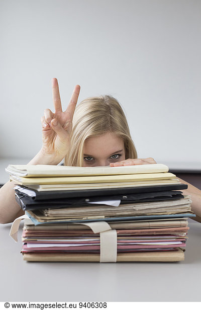 Businesswoman overwhelmed with stack of files