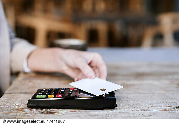 Businesswoman paying through credit card at cafe