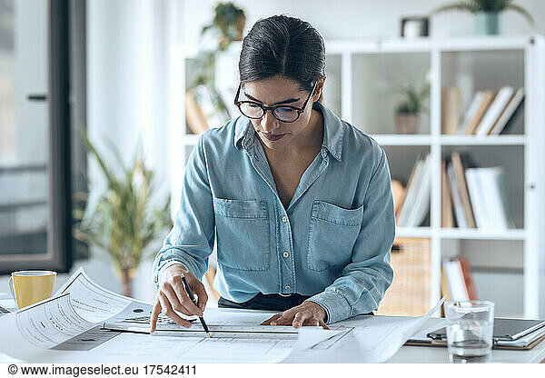 Businesswoman preparing floor plan in small office