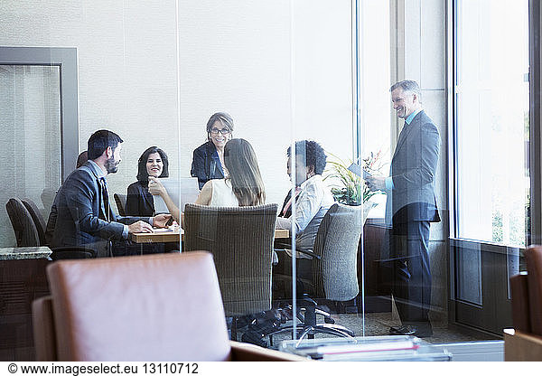 Businesswoman showing document to colleagues in board room during meeting