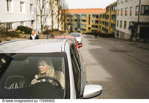 Businesswoman sitting in car seen through windshield