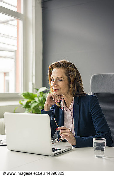 Businesswoman sitting in office  working on laptop