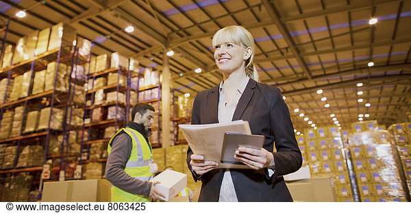Businesswoman smiling in warehouse