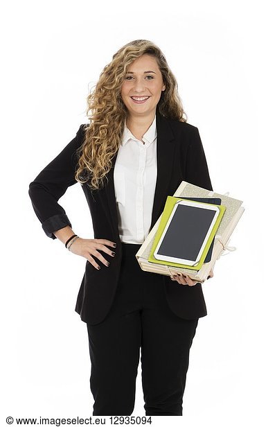 Businesswoman standing in the studio with tablet and documents in her arms  she is wearing a black suit and a white shirt.