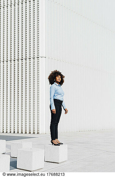 Businesswoman standing on concrete block