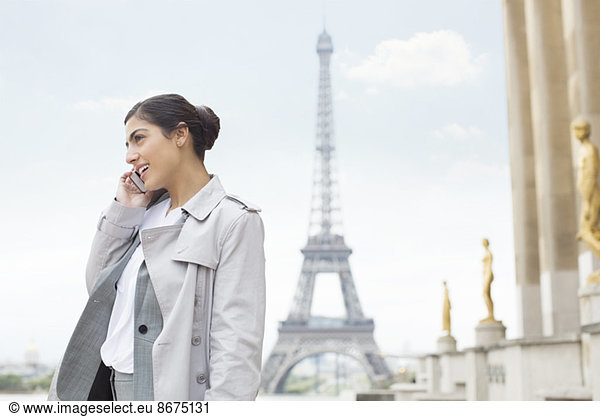 Businesswoman talking on cell phone by Eiffel Tower  Paris  France