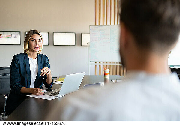 Businesswoman talking with colleague during meeting