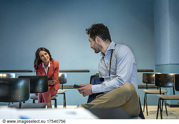 Businesswoman talking with colleague in board room at conference