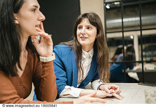 Businesswoman talking with office colleague at coffee shop