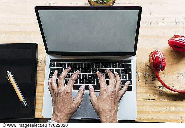 Businesswoman typing on laptop working in coffee shop