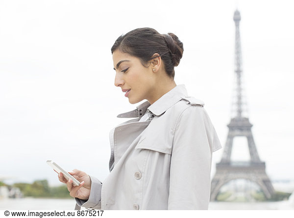 Businesswoman using cell phone near Eiffel Tower  Paris  France