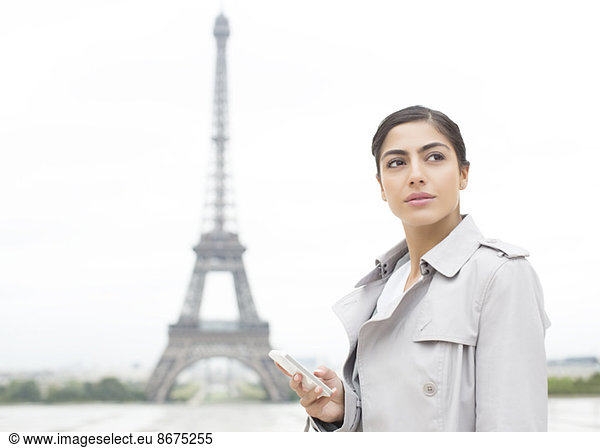 Businesswoman using cell phone near Eiffel Tower  Paris  France
