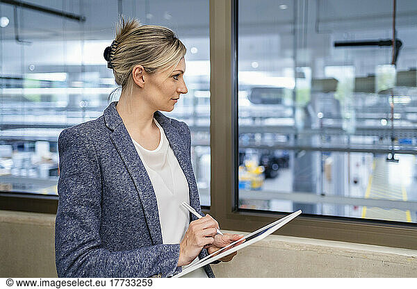 Businesswoman using digital tablet in factory office