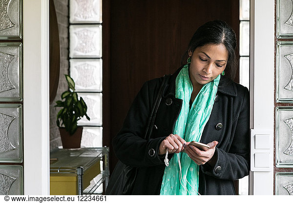 Businesswoman using mobile phone in home office