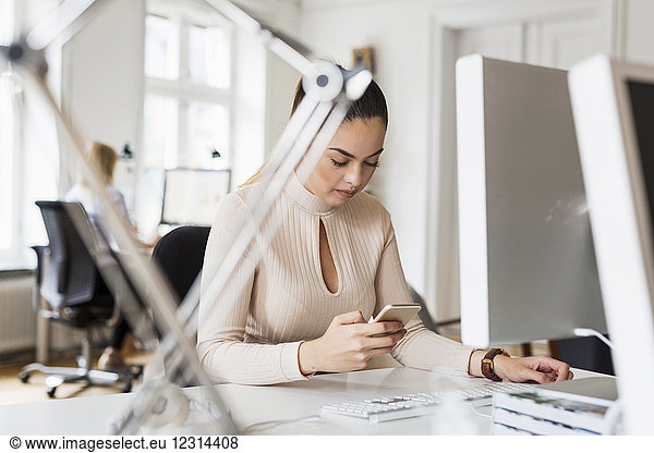 Businesswoman using phone in office