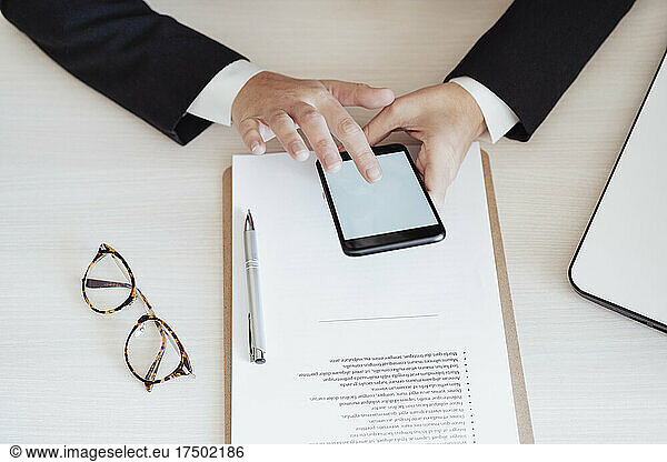 Businesswoman using smart phone at desk in office
