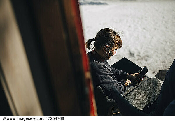 Businesswoman using smart phone during winter