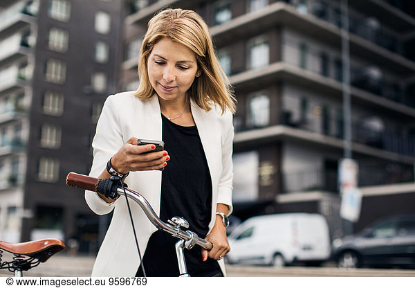 Businesswoman using smart phone in city