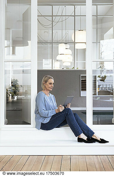 Businesswoman using tablet PC at office entrance