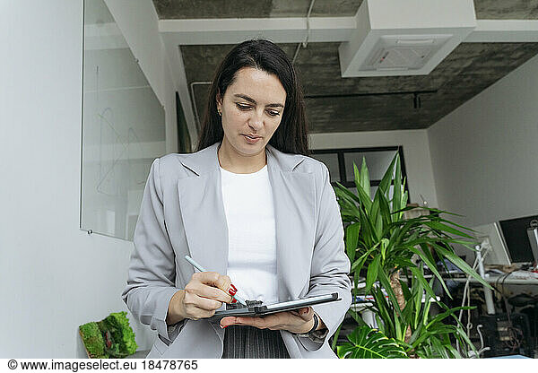 Businesswoman using tablet PC at workplace