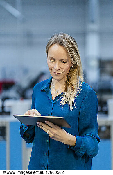 Businesswoman using tablet PC in industry